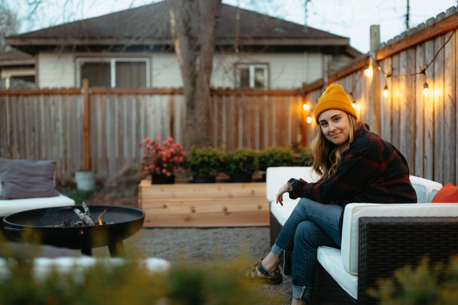 Emily Mandagie se sienta cerca de DIY Fireyard Fire Pit