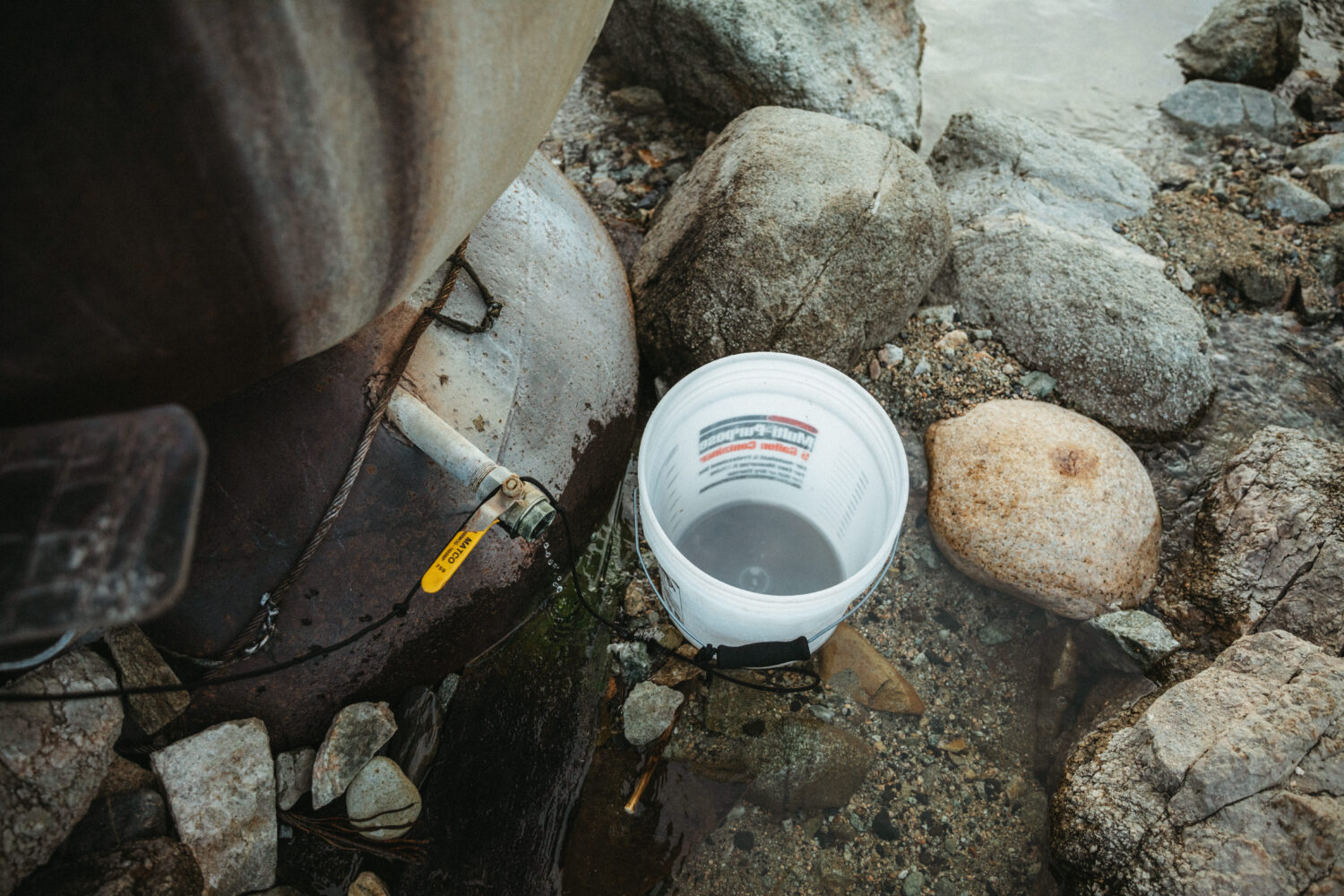Balde para agua fría del río en el río Salmon