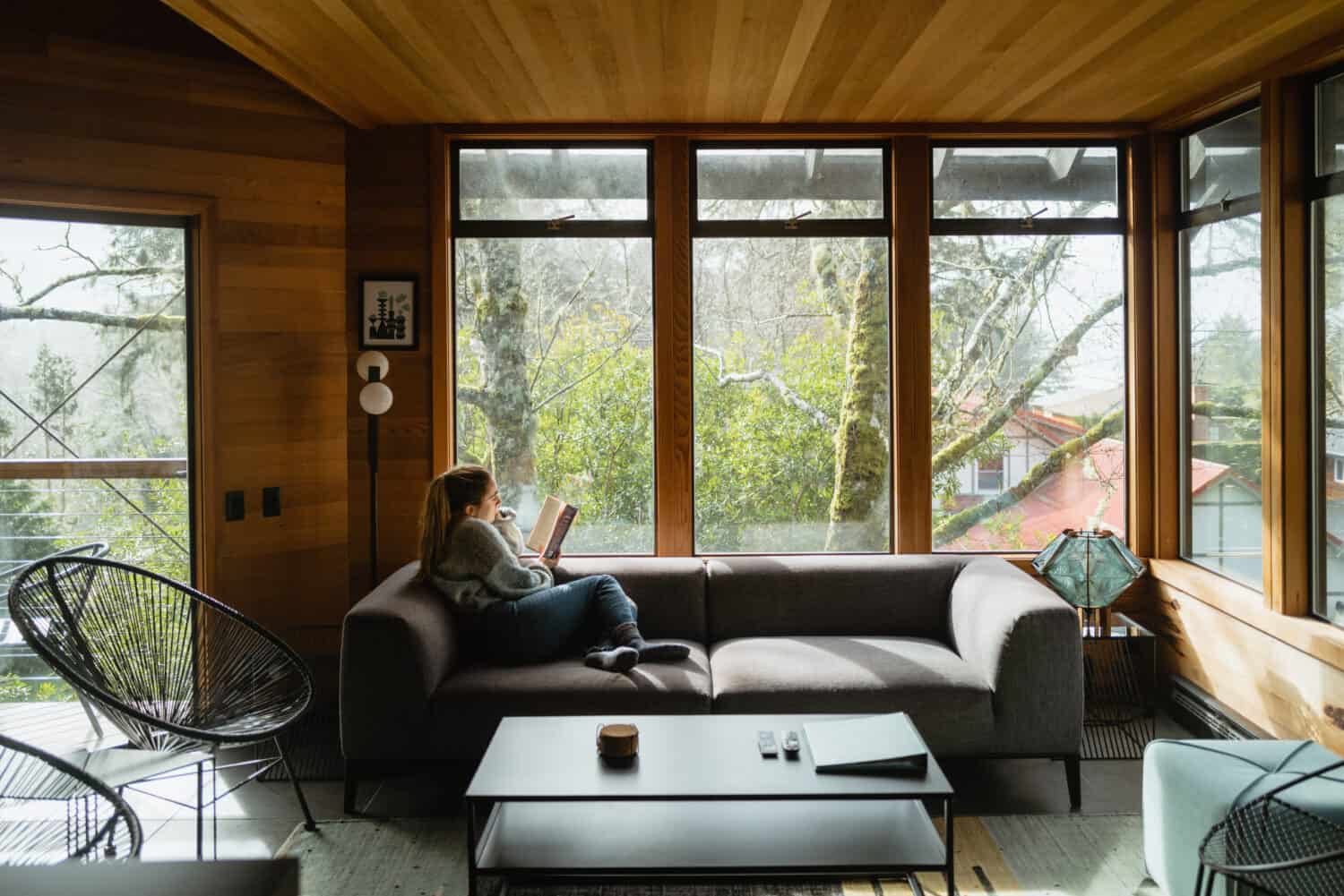 Emily Mandagie se sienta en la sala de estar en Oregon Coast Modern