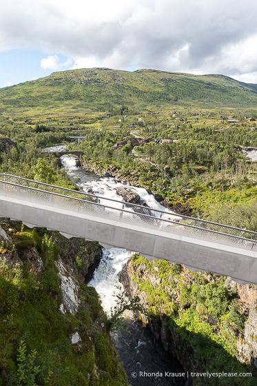 Puente escalonado sobre el río con una colina al fondo.